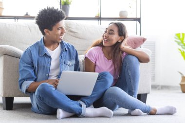 Bin yıllık çift dizüstü bilgisayar ile katta oturan, birlikte eğlenmek