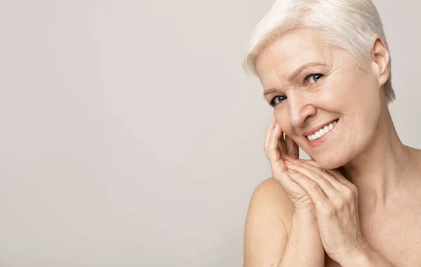 Portret van charmante naakte Senior vrouw die haar huid aanraakt — Stockfoto