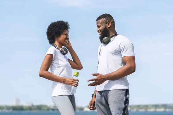 Uomo e donna parlando dopo mattina jogging vicino fiume — Foto Stock