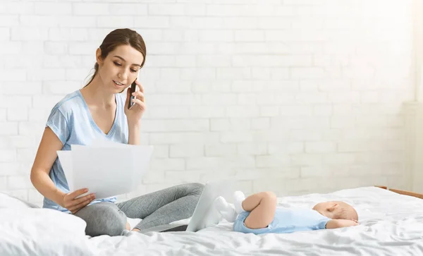 Mujer trabajando en casa y cuidando a su bebé — Foto de Stock