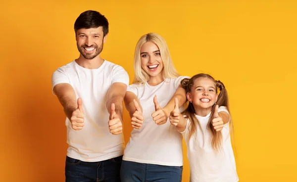 Family Gesturing Thumbs-Up Standing Over Yellow Background — Stock Photo, Image