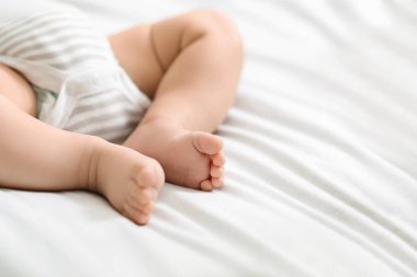 Bodysuit yatakta yatan yeni doğan bebeğin minik bacakları