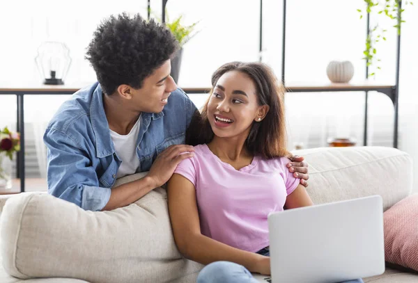 Alegre casal milenar navegando na internet no laptop em casa — Fotografia de Stock