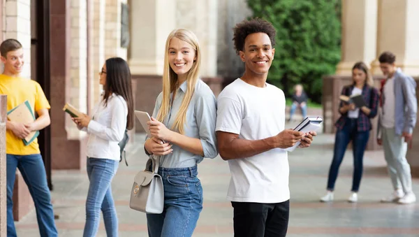 Diversos estudiantes descansando en el campus universitario, teniendo descanso — Foto de Stock