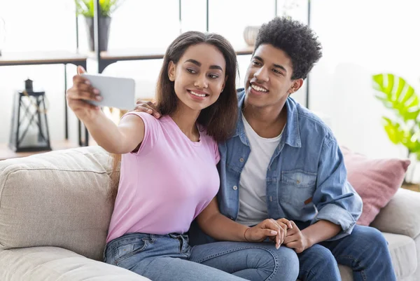 Junges afrikanisches Paar macht Selfie mit Smartphone zu Hause — Stockfoto