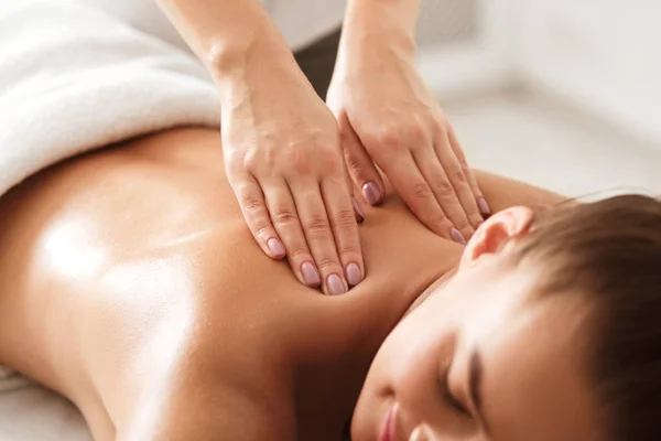 Jovem desfrutando de massagem terapêutica no pescoço no spa — Fotografia de Stock