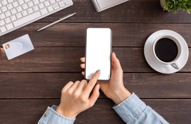 İşyerinde boş ekrana sahip modern akıllı telefonu kullanan kadın