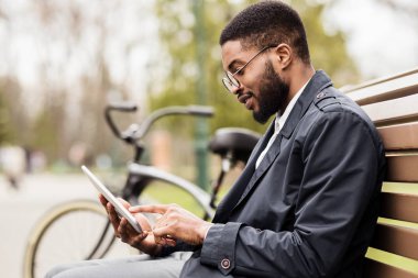 Parkta dijital tablet kullanan genç serbest çalışan