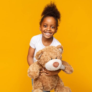 Sevimli afrikalı bebek kız onu oyuncak ayı ile gülüyor