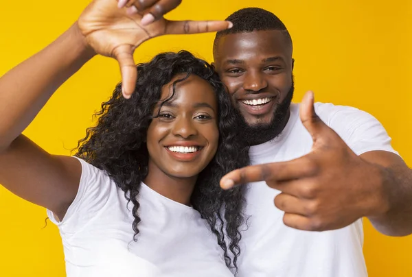 Negro hombre y mujer mostrando marco signo con las manos — Foto de Stock