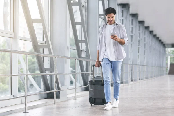 Millennial chico comprobar los mensajes entrantes después de la llegada al aeropuerto —  Fotos de Stock