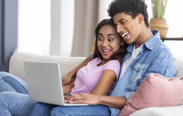 Lächelndes Millennial-Paar schaut lustiges Video auf Laptop zu Hause — Stockfoto