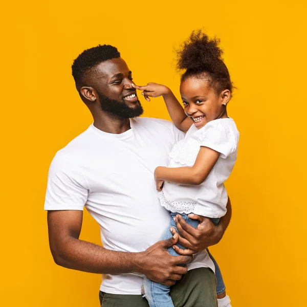 Lekfull afrikansk tjej leker med pappa, driver näsan som signal — Stockfoto