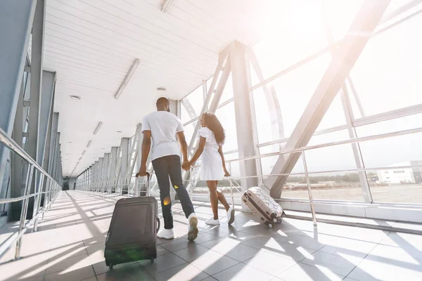 Jong Afrikaans paar wandelen met bagage in het luchthavengebouw — Stockfoto