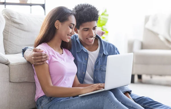 Tonåring par med laptop sitter på golvet och surfar på Internet — Stockfoto