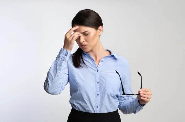 Mujer de negocios con exceso de trabajo Masajeando Nosebridge Tener hipertensión ocular sobre fondo blanco — Foto de Stock
