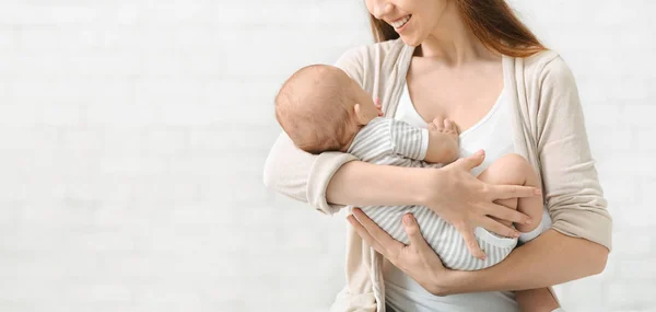 Fiatal nő énekelte Lullaby neki újszülött baba, és mosolyogva — Stock Fotó