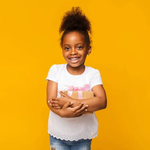Lovely little african girl smiling with present box — Stock Photo, Image