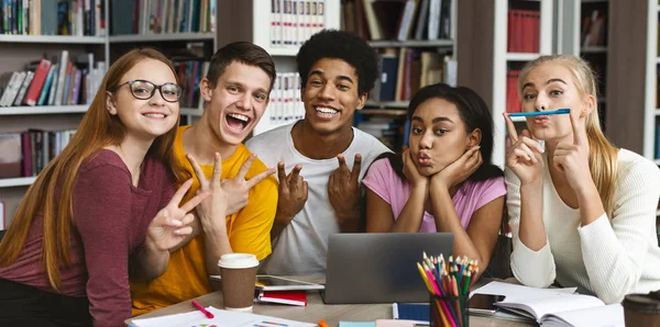 Divertido grupo de estudiantes posando en la cámara en la biblioteca — Foto de Stock