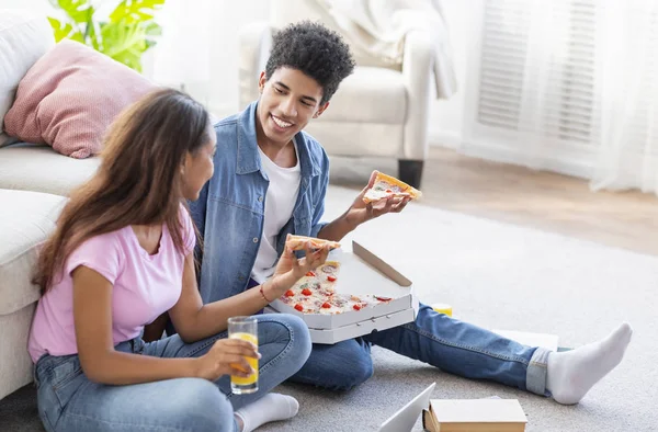 Tiener paar genieten van pizza en SAP terwijl zittend op de vloer — Stockfoto