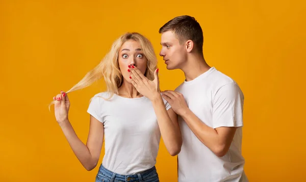 Guy sussurrando segredo ou fofoca para menina surpresa — Fotografia de Stock