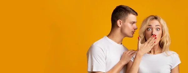 Young guy sharing secret with his shocked girlfriend — Stock Photo, Image