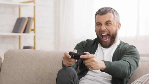 Homem animado de meia-idade jogando videogames em casa — Fotografia de Stock