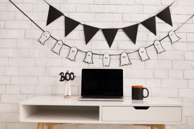 Boş ekranlı açık dizüstü bilgisayar ile ofiste Cadılar Bayramı konsepti