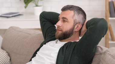 Evde kanepede yatan çekici dalgın adam