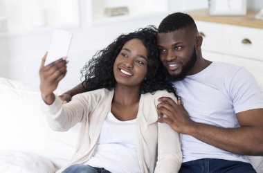 Romantik çift evde kanepede otururken selfie çekiyor