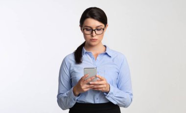 Ciddi İş Kadını Kullanarak Cep Telefonu Ayakta, Studio Shot