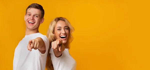 Glückliches Millennial-Paar zeigt auf Kamera und lacht — Stockfoto