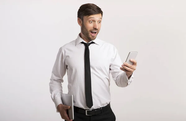 Überraschter Mann mit Smartphone auf weißem Hintergrund — Stockfoto