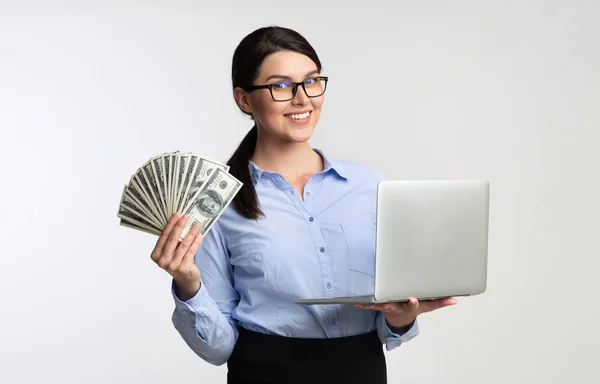 白い背景にラップトップコンピュータとお金を保持するビジネスの女の子 — ストック写真