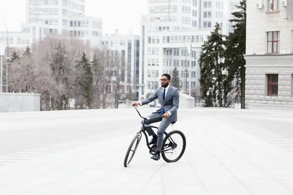 Empresário afro vai ao escritório de bicicleta, andando na cidade — Fotografia de Stock