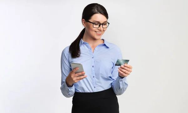 白い背景の上に電話とクレジットカードを使用するビジネスウーマン — ストック写真