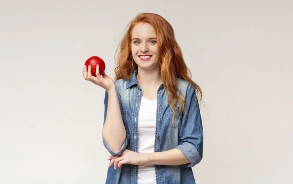 लाल सफरचंद धारण निरोगी दात असलेल्या स्मित मुलीचे पोर्ट्रेट — स्टॉक फोटो, इमेज