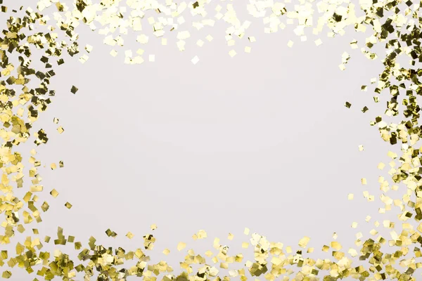 Espumante de confete dourado no fundo branco com espaço de cópia — Fotografia de Stock