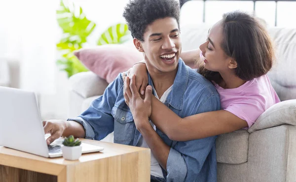 Freundin umarmt ihren Freund, während sie gemeinsam am Laptop arbeiten — Stockfoto