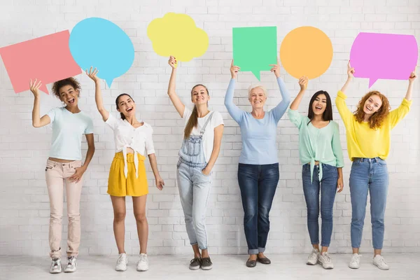 Diverse vrouwen houden kleurrijke spraak bubbels naast witte muur — Stockfoto