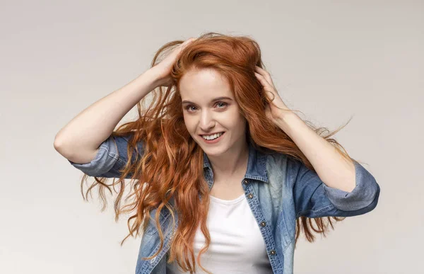 Kızıl saçlı kız parmakları ile saç fırçalama, onun doğal bir görünüm zevk — Stok fotoğraf