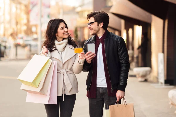 Compras fáceis. Casal feliz usando smartphone e cartão de crédito — Fotografia de Stock