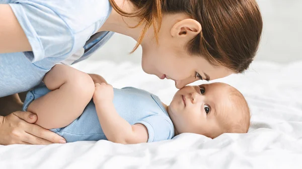Молодая мать смотрит на своего новорожденного ребенка с обожанием — стоковое фото