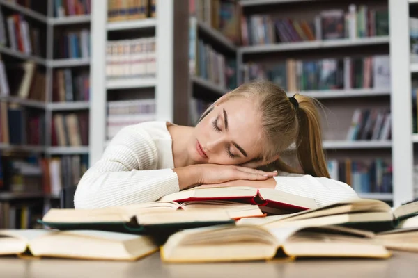 Fiatal szőke lány, aki nap közben tanul a könyvtár — Stock Fotó
