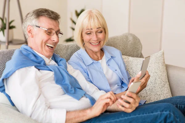 Feliz pareja madura viendo videos divertidos en el teléfono — Foto de Stock