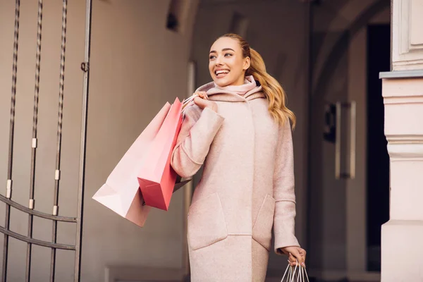 Shopping concept. Gelukkig meisje met papieren zakken buitenshuis — Stockfoto