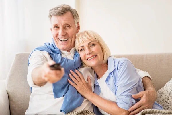 Loving mature couple watching tv with remote control — Stock Photo, Image