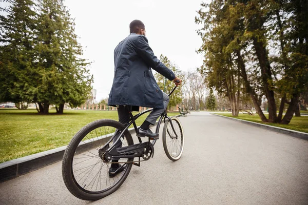 Empresário andar de bicicleta, indo para o trabalho através do parque de outono — Fotografia de Stock