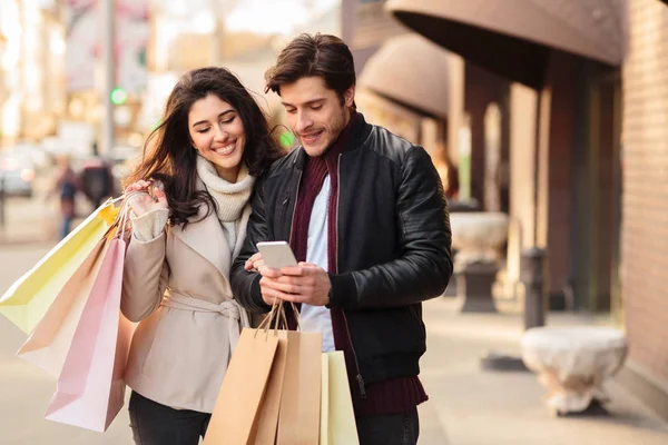Young couple searching new boutique, using smartphone — Stock Photo, Image