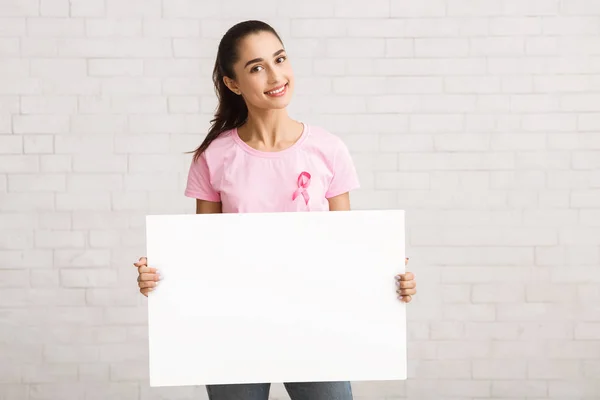 Bröst cancer volontär i rosa T-shirt Holding White Board inomhus — Stockfoto